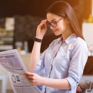 Woman in glasses reading paper